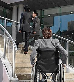 אדם בכיסא גלגלים בתחתית גרם מדרגות