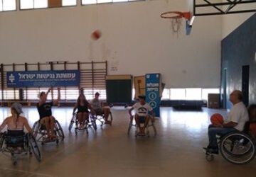 המשתתפים בהפנינג משחקים כדורסל בכיסאות גלגלים