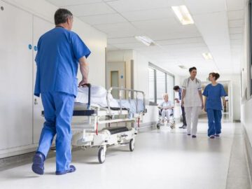 אנשי צוות ומטופלת עוברים במסדרון בית חולים