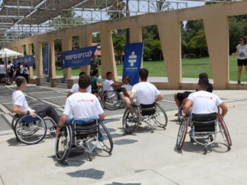 המשתתפים משחקים כדורסל בכיסאות גלגלים