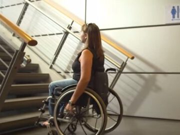 בחורה בכיסא גלגלים מול מדרגות בדרך לשירותים