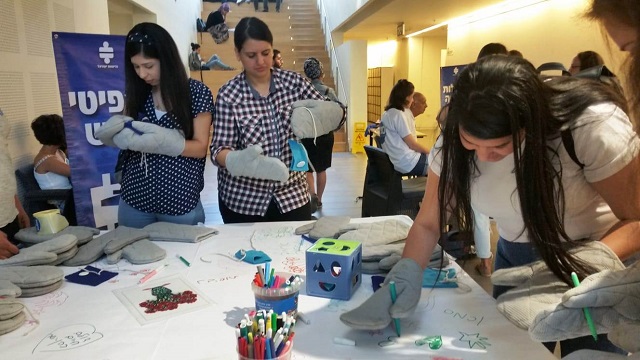 Participants trying to write and tie shoelaces with gloves restricting the movements of their hands