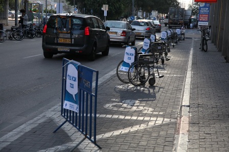 Dozens of wheelchairs occupy parking spots on 4th street in Tel Aviv for a few long hours