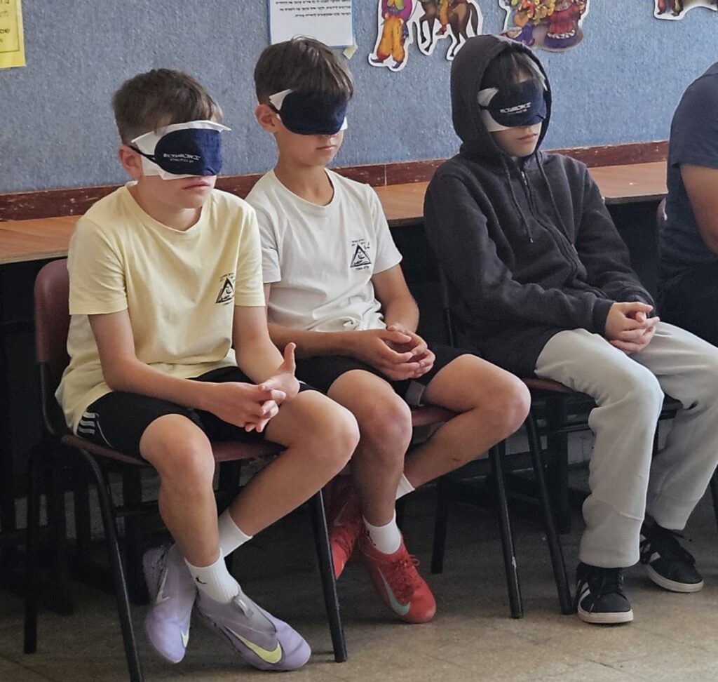 המשתתפים מתנסים בתחנת מוגבלות בראייה ויושבים עם כיסוי עיניים