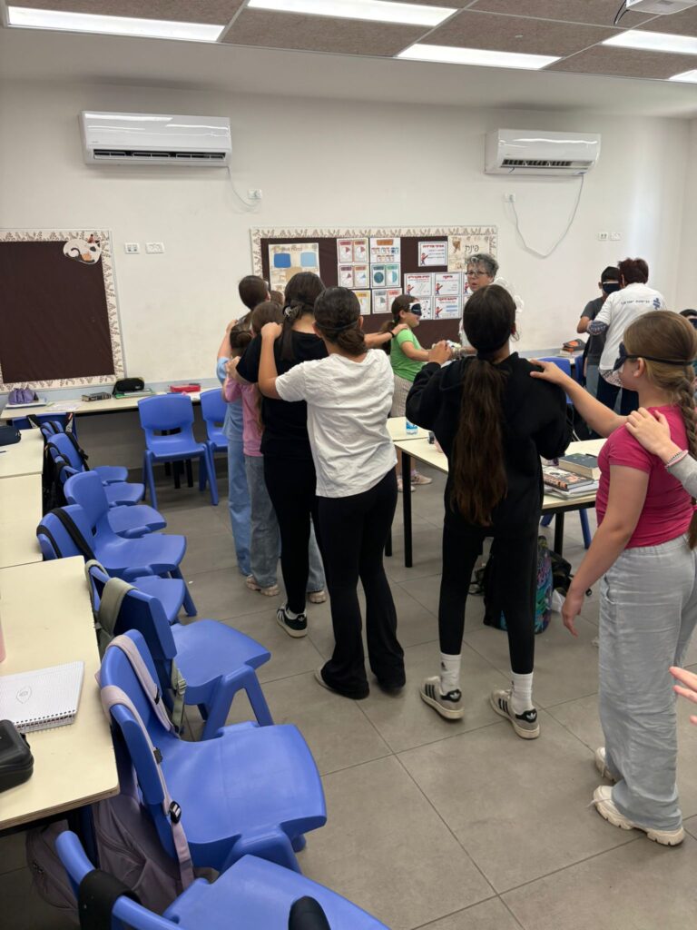 הילדים מתנסים בהליכה עם סיכוי עניים המדמה מוגבלות בראייה