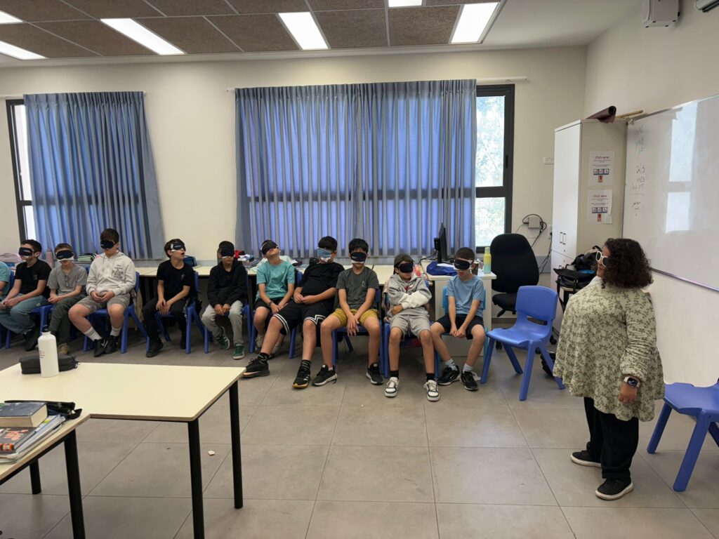 הילדים מתנסים בחבישת סיכוי עניים המדמה מוגבלות בראייה ושומעים מדריכה עם מוגבלות בראייה מספרת על חייה כאדם עם מוגבלות בראייה
